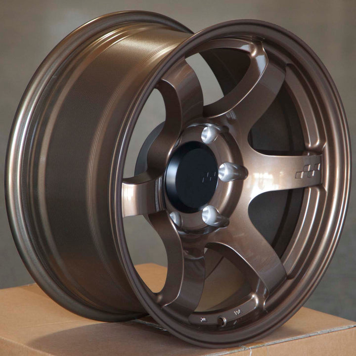 Circuit Steller bronze alloy wheels with split spokes and center caps, angled close-up