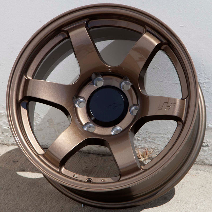 Circuit Steller Bronze alloy wheel with split spokes and lug holes, front view outdoors